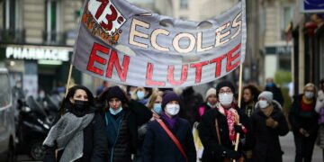 French teachers hold a placard which reads "Schools on struggle" during a demonstration as part of a nationwide day of strike and protests against sanitary conditions in schools, in Paris amid the rise of coronavirus disease (COVID-19) cases due to the Omicron variant in France, January 13, 2022. REUTERS/Sarah Meyssonnier